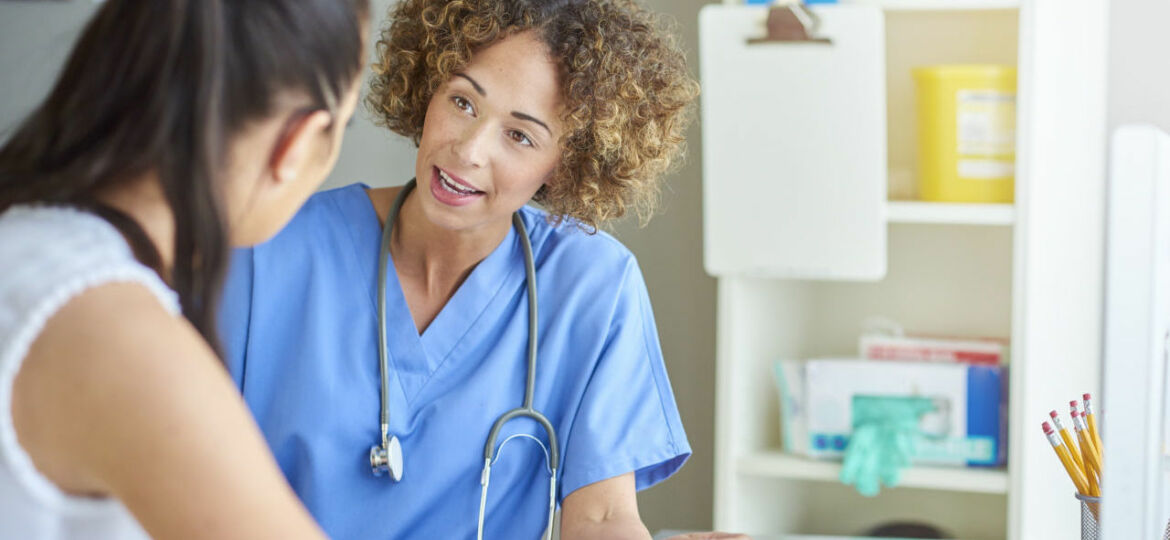 female nurse happily chatting to patient .